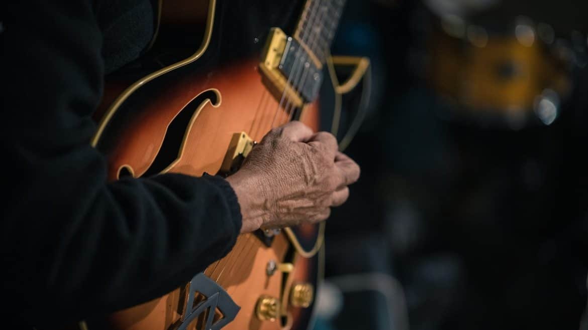 a close up of a person holding a guitar