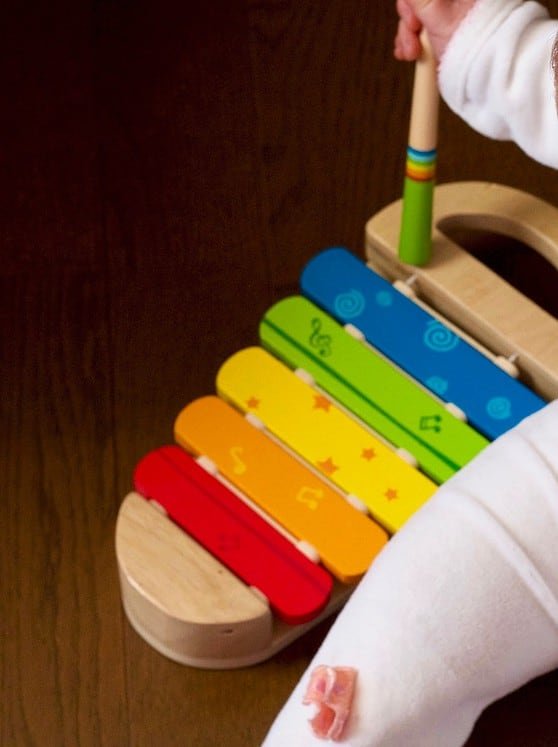 baby playing multicolored xylophone toy