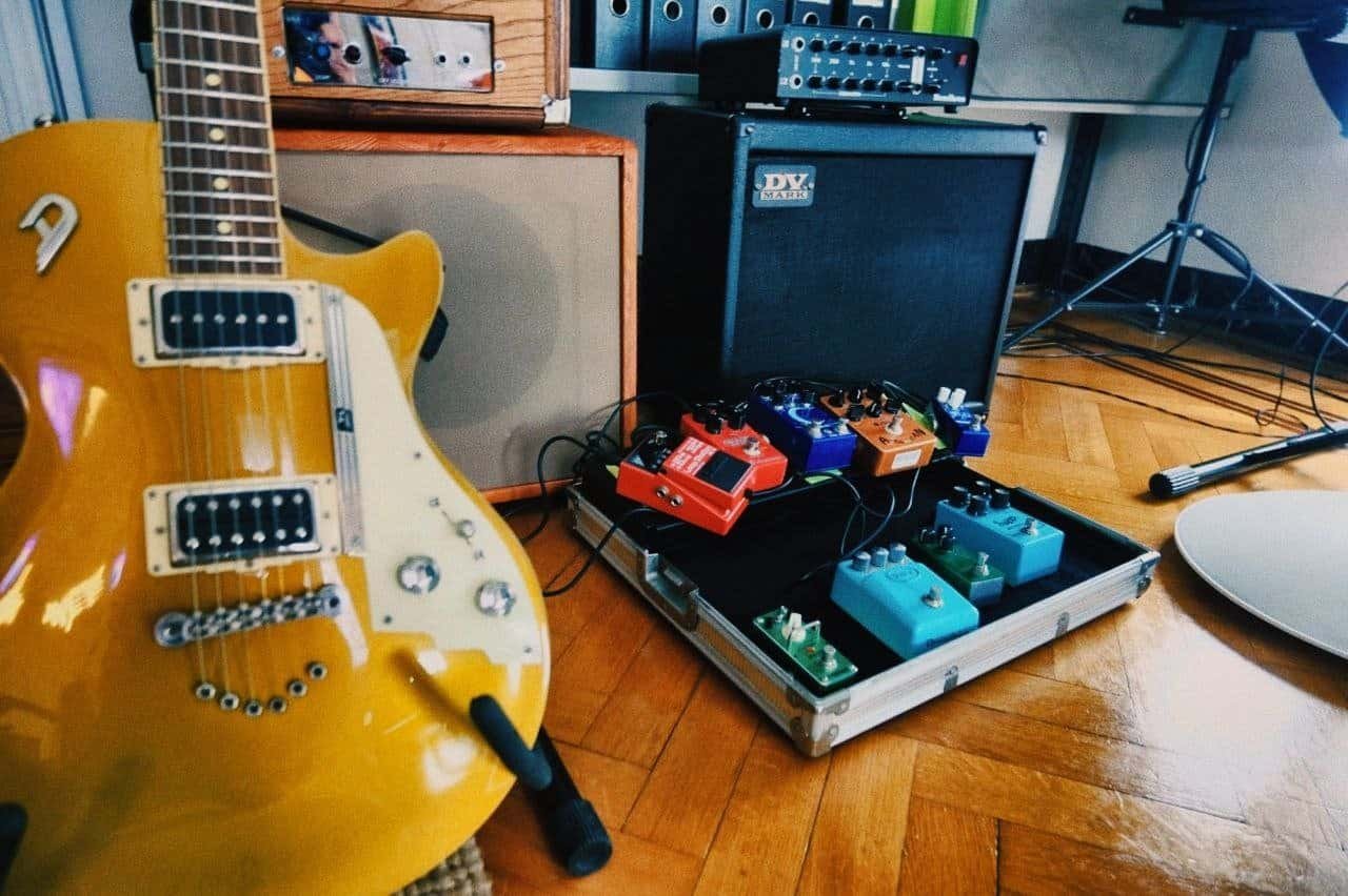 Chitarra elettrica e pedaliera di effetti boutique davanti all'amplificatore DV Mark
